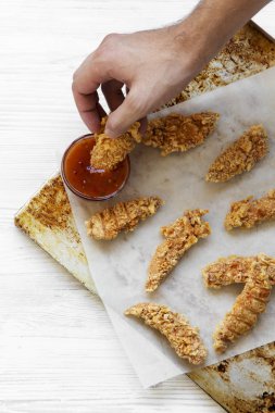 Adamın elini tavuk daldırma sosu, havai görünümü şeritler. Gelen yukarıdaki üstten görünüm.