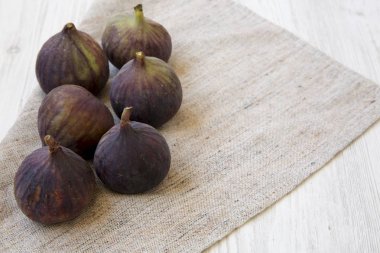 Beyaz ahşap arka plan, yan görünüm üzerinde kumaş üzerine taze incir.