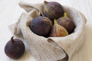 Beyaz ahşap bir masa yan görünüm üzerinde taze incir dolu kase. 