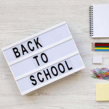 Kelime 'back to school' modern tahtada beyaz ahşap Danışma üzerinde çalışma için aksesuarları görüntüleyin yukarıdan. Üstten görünüm, düz lay, ek yükü.