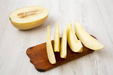 Beyaz ahşap masa, yan görünüm kavun dilimli.