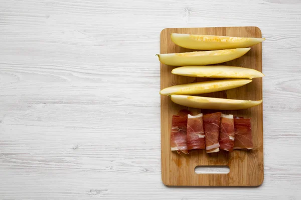 Rodajas Melón Con Jamón Sobre Tabla Bambú Sobre Fondo Madera —  Fotos de Stock