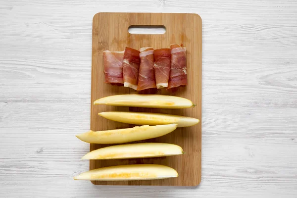 Rodajas Melón Con Jamón Sobre Tabla Bambú Sobre Superficie Madera —  Fotos de Stock