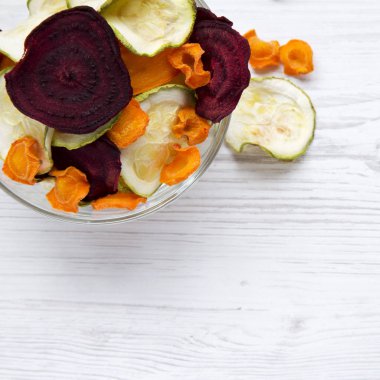 Sebze cips Beyaz ahşap arka plan, havai görünümü üzerinde tam kase. Yukarıdan, lay düz. 