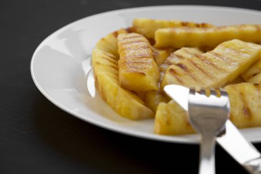 Izgara ananas dilimleri beyaz tabakta yakın çekim. Yaz yiyecek. Yan görünüm.