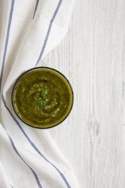 Fesleğen pesto Beyaz ahşap arka planda, üstten görünüm. Düz, tepegöz, yukarıdan yatıyordu. Metin için yer.