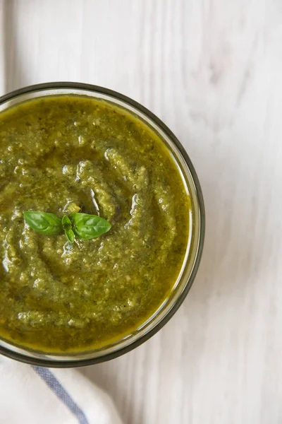 Fesleğen pesto Beyaz ahşap arka planda, üstten görünüm. Düz, tepegöz, yukarıdan yatıyordu. 