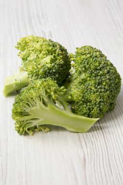 Beyaz ahşap masa, yan görünüm üzerinde çiğ brokoli. 