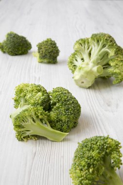 Beyaz ahşap masa, yan görünüm üzerinde çiğ brokoli. Yakın çekim.