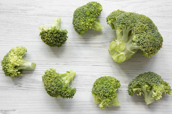 Beyaz Ahşap Masa Üstten Görünüm Üzerinde Çiğ Brokoli — Stok fotoğraf
