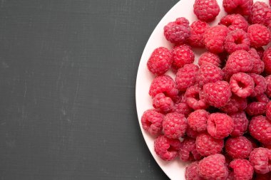 Ahududu siyah tablo, üstten görünüm üzerinde pembe bir tabakta. Düz, tepegöz, yukarıdan yatıyordu. Kopya alanı.