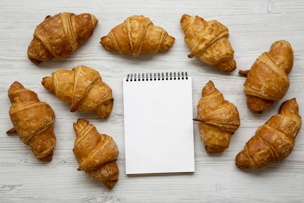 Croissants Frescos Notebook Branco Mesa Madeira Branca Vista Superior Cima — Fotografia de Stock