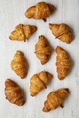 Taze kruvasanlar Beyaz ahşap yüzey, en iyi görünüm. Yukarıda, ek yükü.