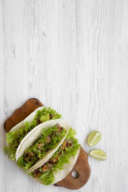 Beyaz ahşap masa üzerinde ahşap tahta üzerinde Tacos karides, yukarıdan görüntüleyin. Meksika yemeği. Düz yatıyordu, genel gider, en iyi görünüm. Kopya alanı.