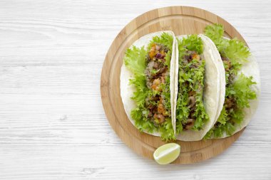 Karides taco üzerinde Bambu tahta üzerinde beyaz ahşap masa, üstten görünüm yuvarlak. Meksika yemeği. Düz, tepegöz, yukarıdan yatıyordu. Kopya alanı.