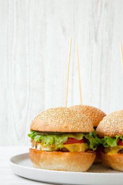 Çizburger gri plaka üzerinde. Beyaz ahşap arka plan. Yan görünümü. Yakın çekim.