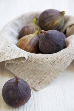 Beyaz ahşap masa, yan görünüm üzerinde bir kase taze incir. Yakın çekim.