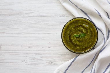 Fesleğen pesto üstten görünüm beyaz tahta masada. Kopya alanı. 