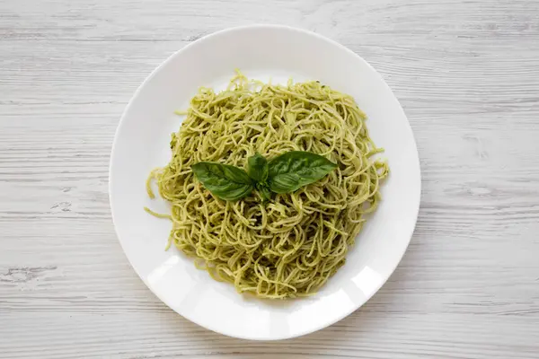 Talerz Makaronu Spaghetti Pesto Biały Drewniany Stół Nad Głową Widok — Zdjęcie stockowe