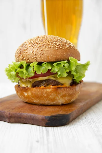 Cheeseburger Sklenicí Piva Dřevěné Desce Bílém Pozadí Dřevěná Boční Pohled — Stock fotografie