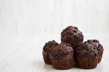 Çikolata muffins Beyaz ahşap arka planda, yan görünüm. Yakın çekim. Kopya alanı.