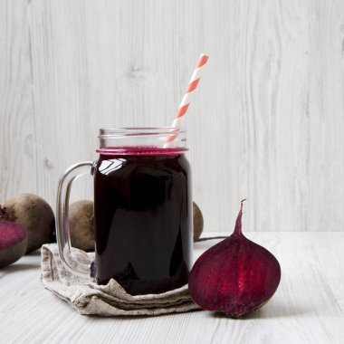 Cam kavanoz pancar güler yüzlü beyaz ahşap yüzey, yan görünüm üzerinde. Portre.