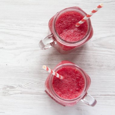 Karpuz güler yüzlü beyaz ahşap bir masa havai görünümü üzerinde cam kavanoz.