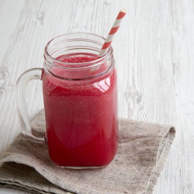 Cam sürahi su kavun güler yüzlü beyaz ahşap bir masa yan görünüm üzerinde. Portre.