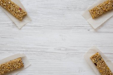 Granola barlar yukarıdan, bir beyaz tahta masada sac pişirme üzerinde. Tepegöz, yatıyordu, en iyi görünüm düz. Metin için yer.