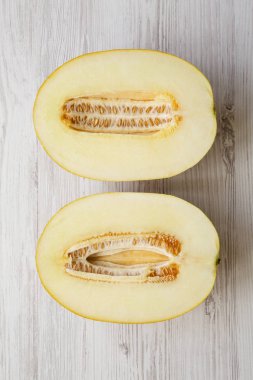 Beyaz ahşap yüzey, en iyi görünümü kavun iki yarısı. Düz, tepegöz, yukarıdan yatıyordu. Yakın çekim.