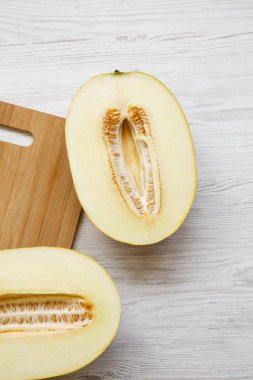 Beyaz ahşap masa, havai görünümü kavun iki yarısı. Yukarıdan, ana sayfa görünümü.