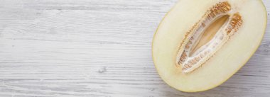 Beyaz ahşap yüzey, havai görünümü kavun yarısı. Yukarıdan görünüm üst. Kopya alanı.