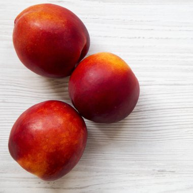 Beyaz ahşap bir masa havai görünümü üzerinde nektarin. Yakın çekim. 