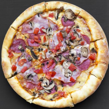 Siyah bir arka plan, havai görünümü taze pişmiş pizza. Yakın çekim. Üstten görünüm, yat.