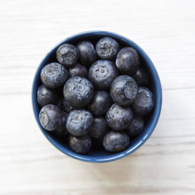 Yaban mersini mavi bir kase, havai görünümü. Düz, tepegöz, yukarıdan yatıyordu. Yakın çekim.