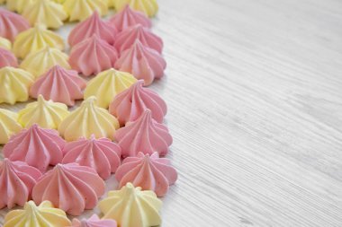Mini meringues Beyaz ahşap zemin, yan görünüm üzerinde. Kopya alanı.
