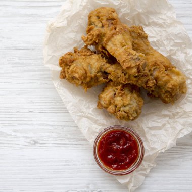 Beyaz ahşap arka plan, üstten görünüm üzerinde soslu kızarmış tavuk sopaları. Yakın çekim.