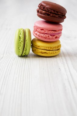 Beyaz ahşap bir masa yan görünüm üzerinde tatlı macaroons. 
