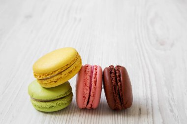 Tatlı ve beyaz ahşap zemin, yan görünüm üzerinde renkli Bademli kurabiye. Yakın çekim. 