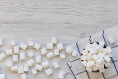 Beyaz ahşap arka plan, üstten görünüm üzerinde bir kasede kabarık Marshmallow. Yukarıdan, üstten görünüm düz yatıyordu. Kopya alanı. 