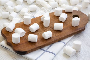 Beyaz ahşap zemin üzerinde rustik gemide Marshmallow. Yığın kabarık lokum gibiydi. Yan görünümü. Yakın çekim.