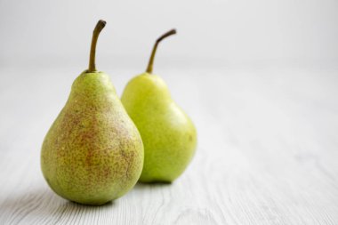 Beyaz ahşap yüzey, yan görünüm üzerinde taze armut. Yakın çekim. Metin için yer.