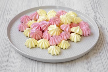Mini meringues Beyaz ahşap yüzey, yan görünüm üzerinde gri plaka üzerinde. Yakın çekim.