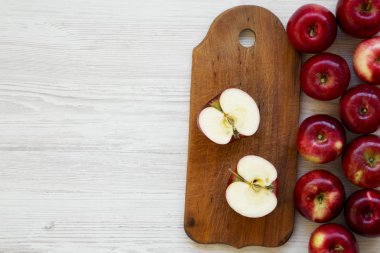 Beyaz ahşap arka plan, havai görünümü üzerinde çiğ kırmızı elma. Yukarıdan, üstten görünüm düz yatıyordu. Boş yer.