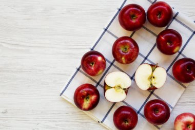 Beyaz ahşap masa, havai görünümü üzerinde taze çiğ kırmızı elma. Yat, yukarıdan görünüm, top. Metin için yer.