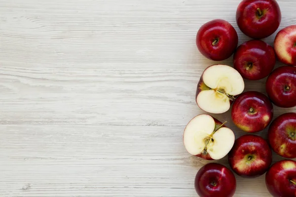Beyaz ahşap masa, üstten görünüm üzerinde çiğ kırmızı elma. Yukarıdan, üstten görünüm düz yatıyordu. Boşluk ve metin alanı Kopyala.