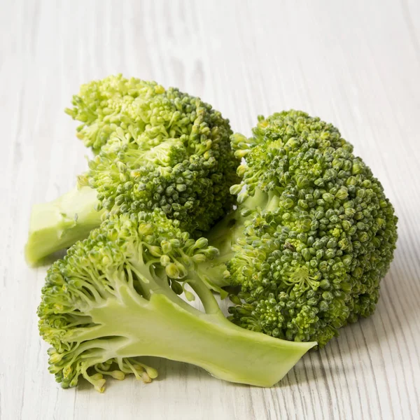 Beyaz Ahşap Masa Yan Görünüm Üzerinde Çiğ Brokoli Yakın Çekim — Stok fotoğraf