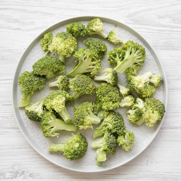 Taze Çiğ Brokoli Gri Plaka Üzerinde Beyaz Ahşap Bir Masa — Stok fotoğraf