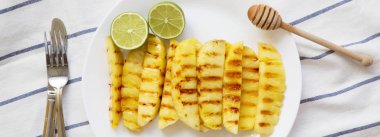 Ananas dilimleri kireç beyaz tabakta, havai görünümü ile ızgara. Yaz yiyecek. Yukarıdan, lay düz. 