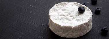 Yaban mersini karanlık tablo, yan görünüm camembert peyniri. Yiyecek şarap için. Yakın çekim. Kopya alanı.